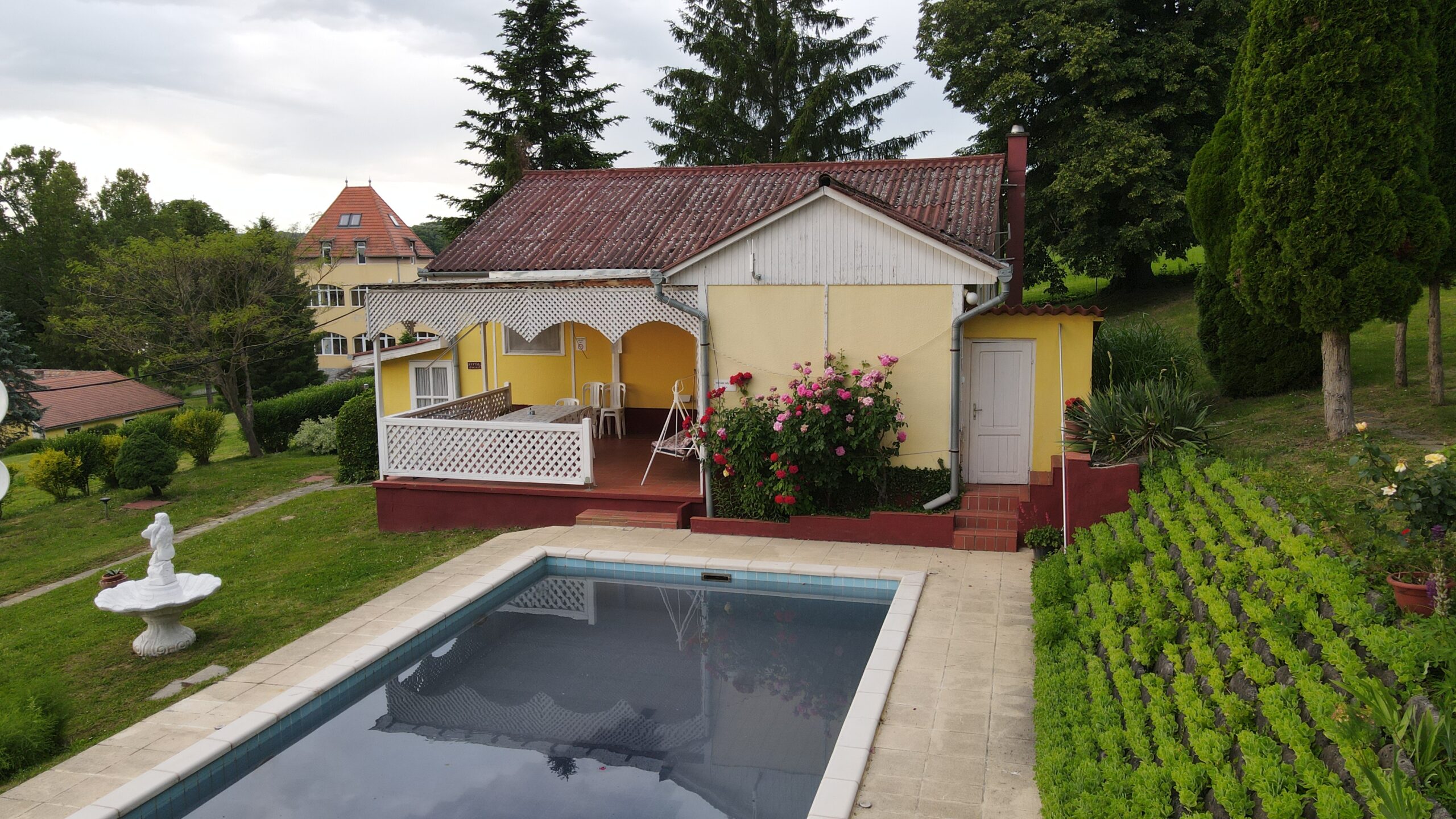 BVitál Apartman épülete medencével és virágzó rózsakerttel – Szentmártonpuszta Zselic
